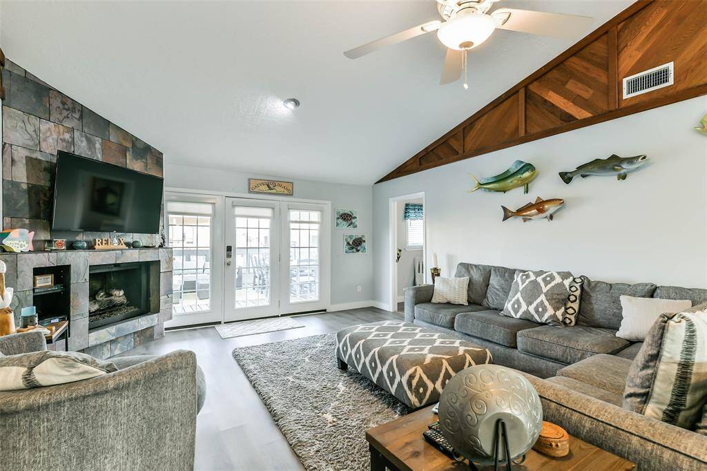 The family room features a glass door flanked by two side windows, providing a beautiful entryway and a view of the patio decking..