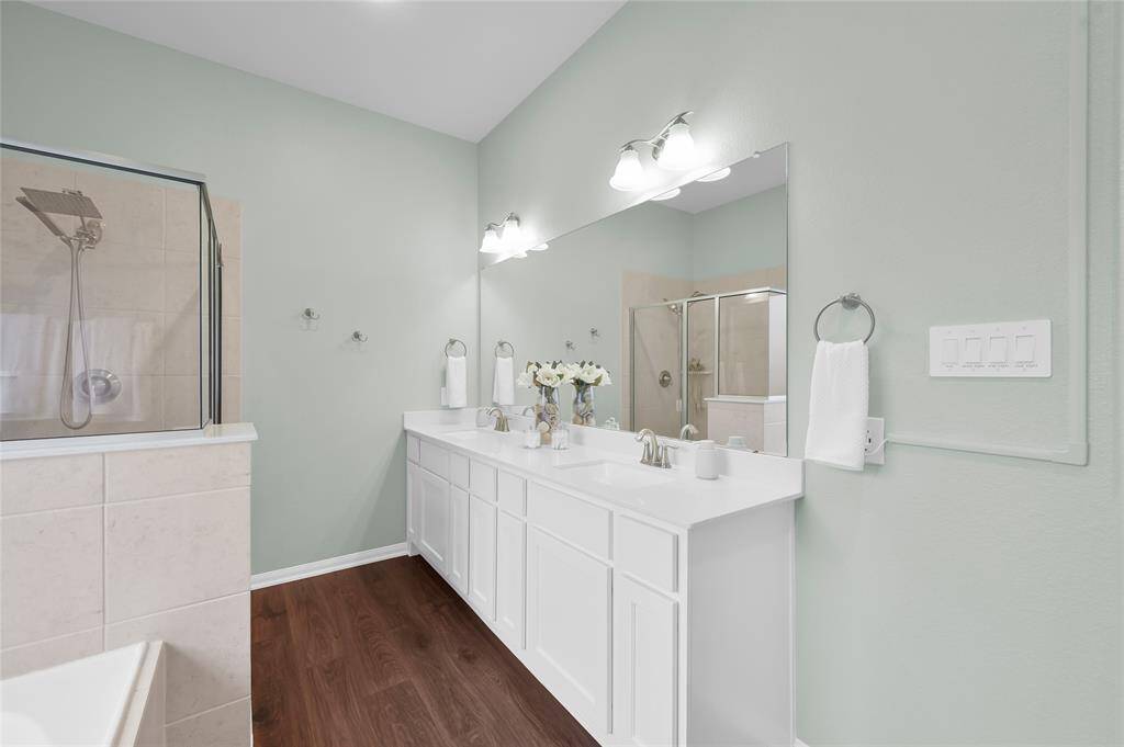 Dual sinks, Quartz countertops and a separate shower make getting ready easy for two people. The vinyl plank flooring from the primary bedroom continues into the bathroom. There is also a water closet for privacy.