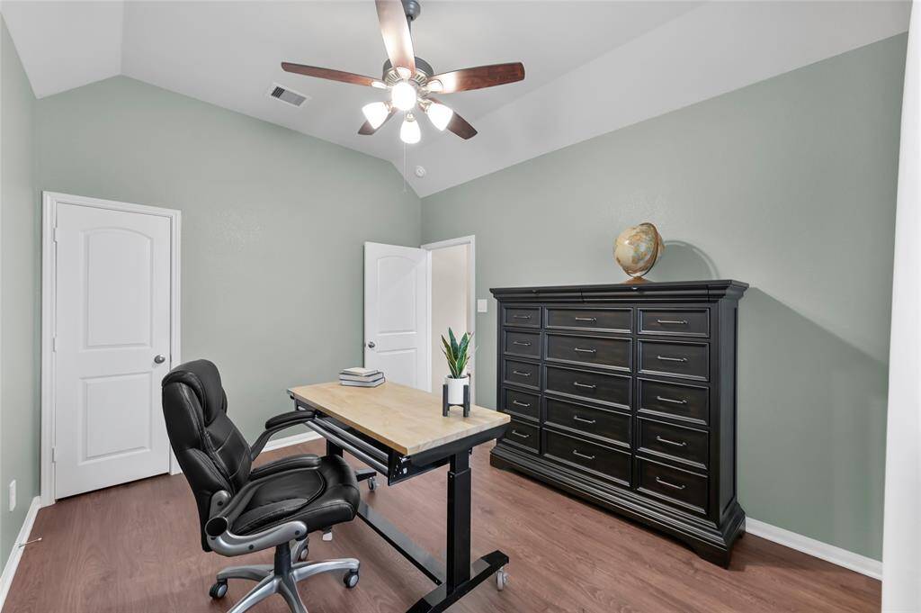Versatile secondary bedroom with angled ceilings, wood flooring—perfect for an office since it's located at the front of the home away from other rooms.