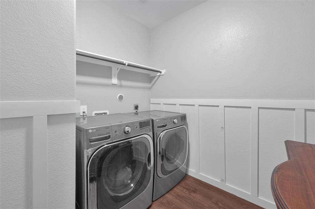 Washing clothes is easy in this attractive and functional laundry room with storage shelf and hanging rod. Opposite the washer and dryer is an entire wall available for other storage items and it's even plumbed for a sink!
