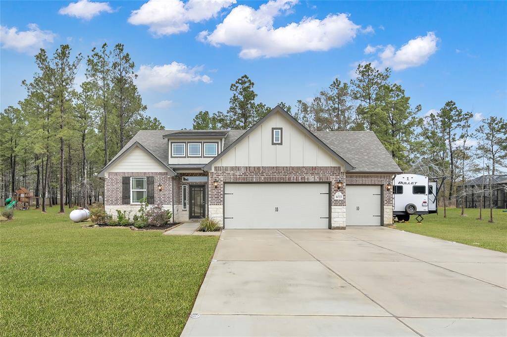 Beautiful brick and stone facade with lush landscaping and room to park a RV or boat on the side of the home. There is also a BougeRV 50 Amp RV Receptacle installed between the interior of the two garage doors to plug in your RV or boat!