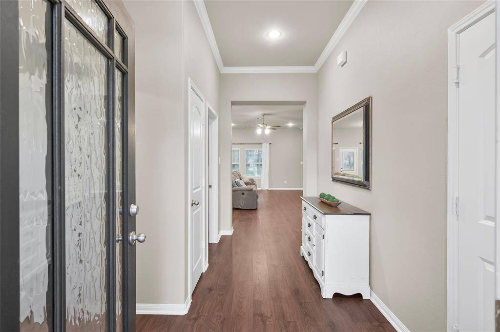 Guests are greeted with an elegant entryway, high ceilings, crown molding, and a Mahogany front door with leaded glass inset.