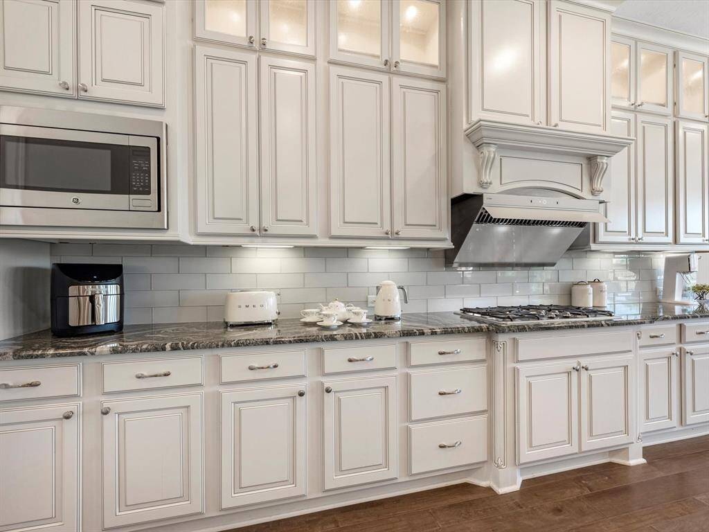 Alternative view of the kitchen showcasing the tiled backsplash and ample cabinet and counter space!