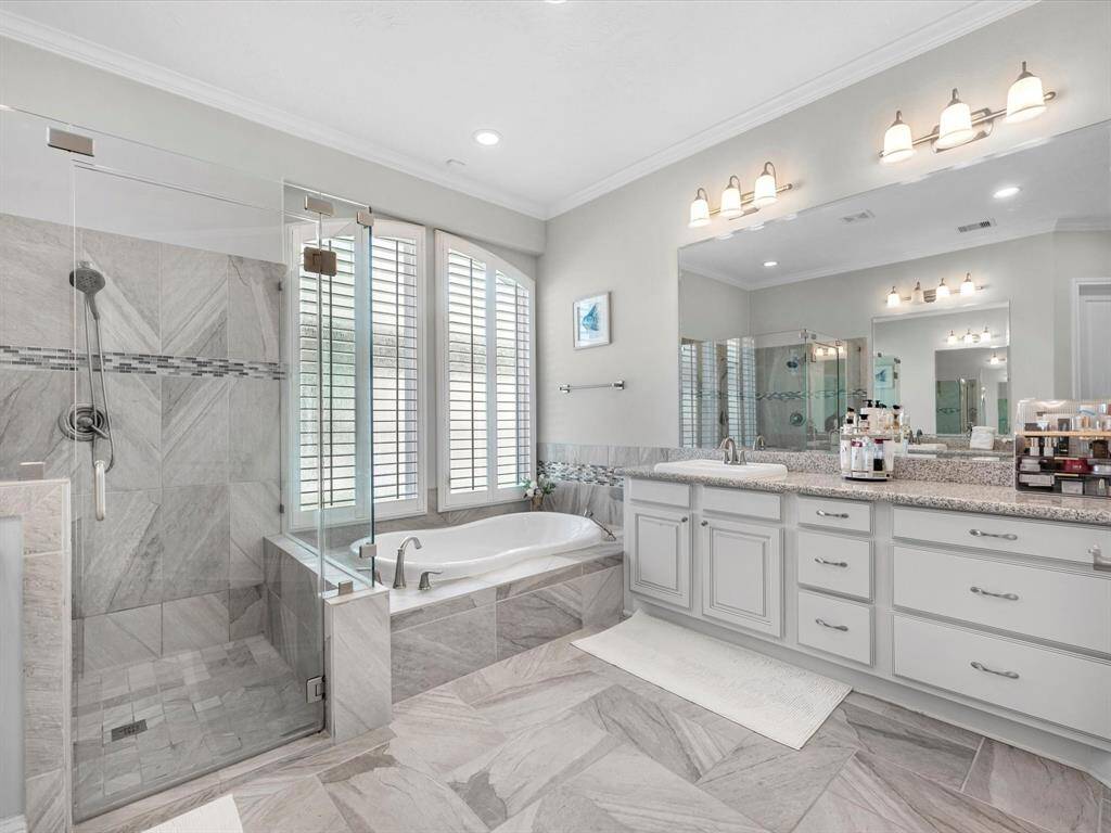 Luxurious ensuite bathroom is a dream! Features dual sinks with extended vanities allow for additional storage, spacious frameless shower, and soaking tub