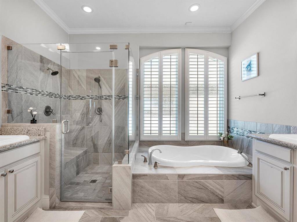 Alternative view of the bathroom showcasing the large windows with plantation shutters above the soaking tub.
