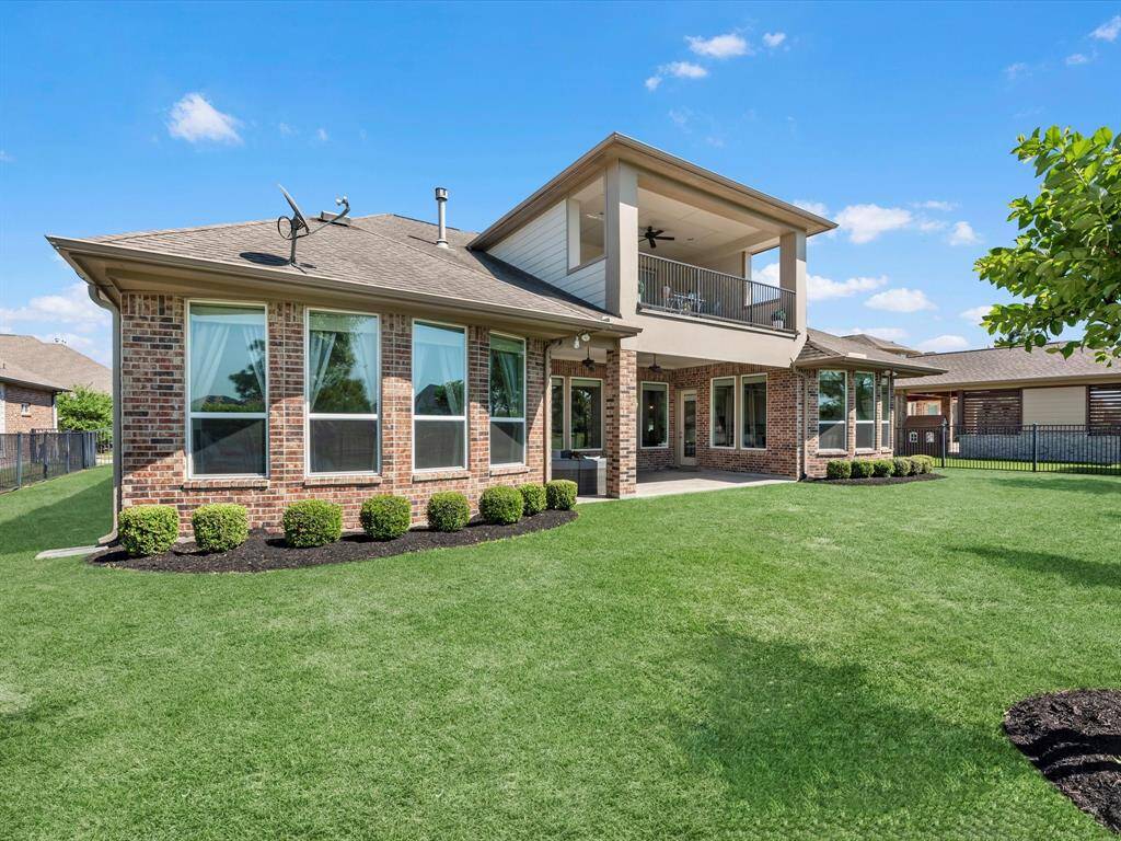 Exquisite view of the back of the home highlighting the large balcony on the second story and huge covered patio!