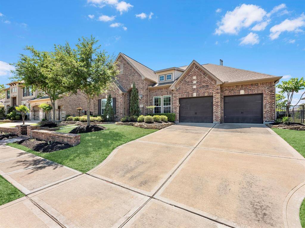 Gorgeous exterior features lush landscaping with stone bordered flower beds complimenting the rich tones of the home.
