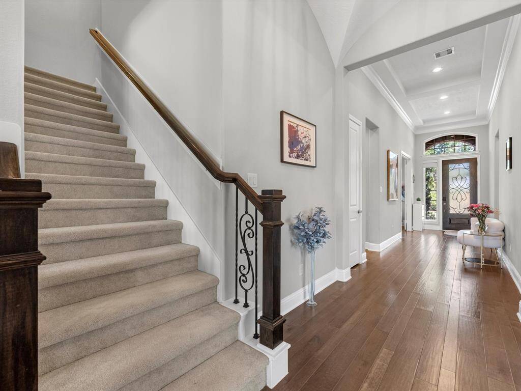 View of the entry showcasing the staircase with wrought iron accents and entry to the flex room!