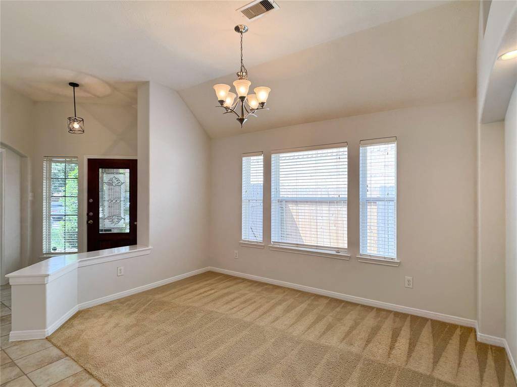 formal dining with elegant chandelier & arched art niche, front door/foyer beyond