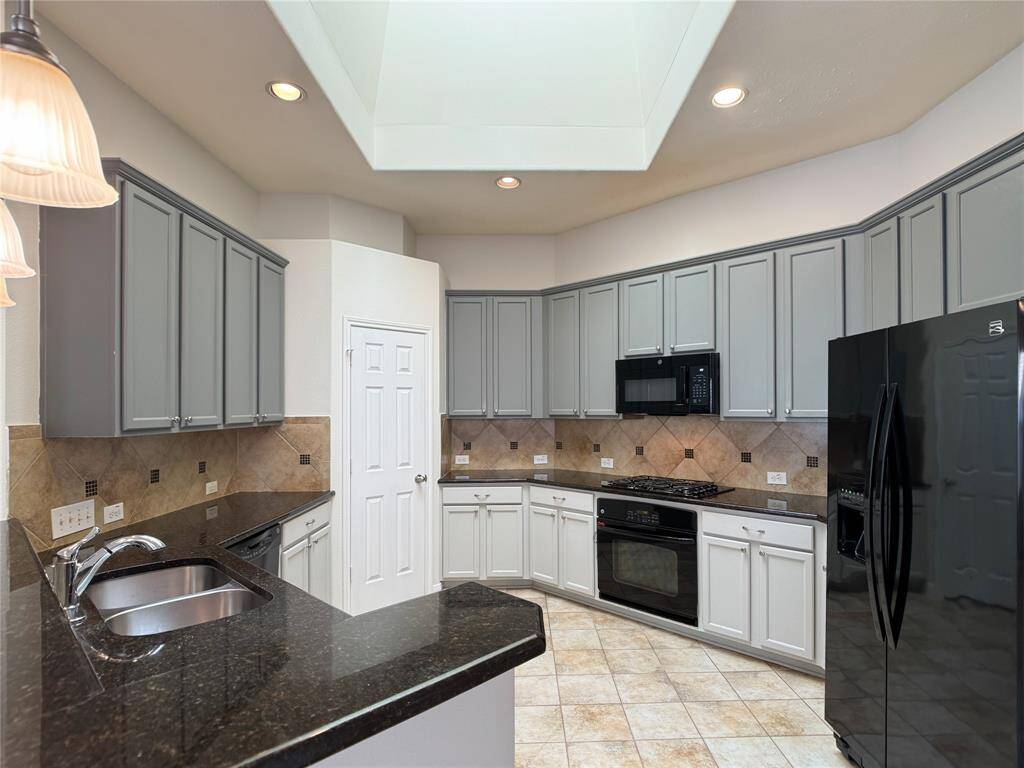spectacular, open kitchen with skylight to let in lots of natural light, granite countertops, pendant-lit breakfast bar