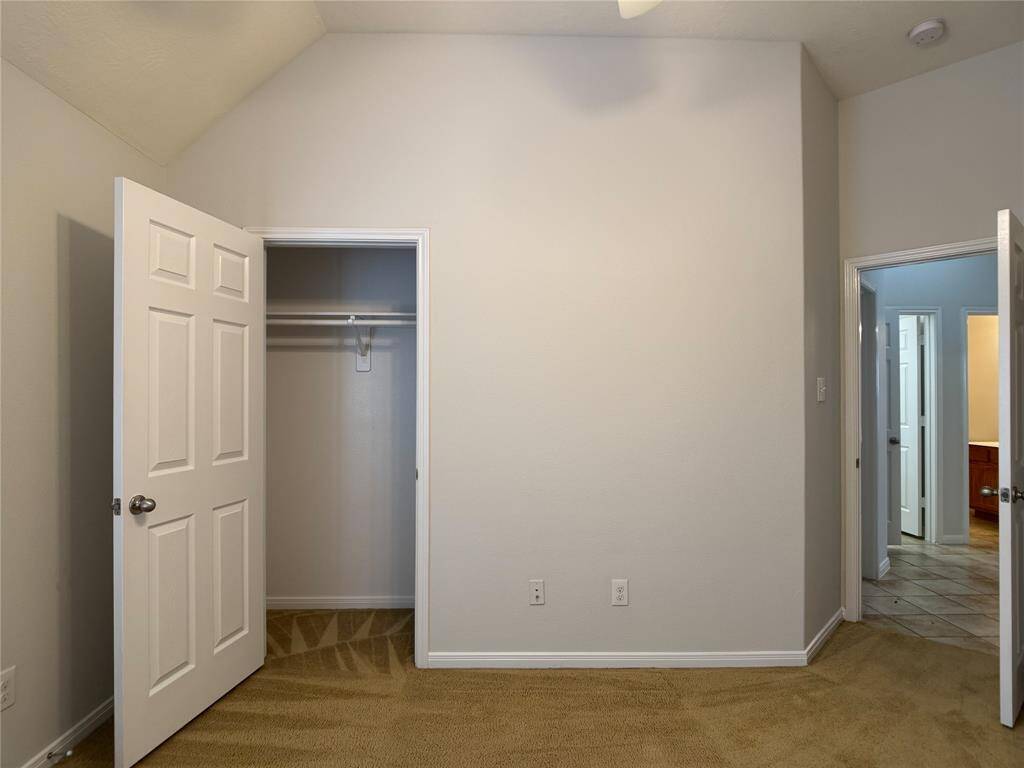 reverse view of bedroom; secondary bedrooms are in separate wing of house from primary suite in split plan
