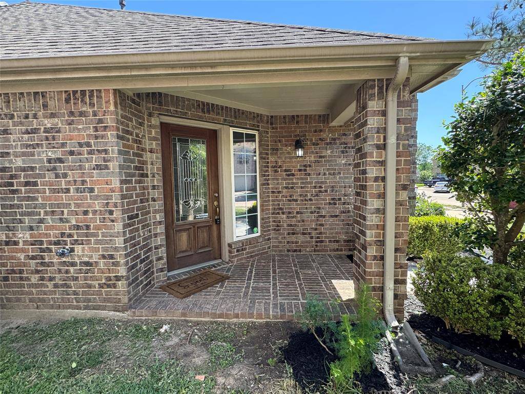 brick-covered front porch with beautiful landscaping