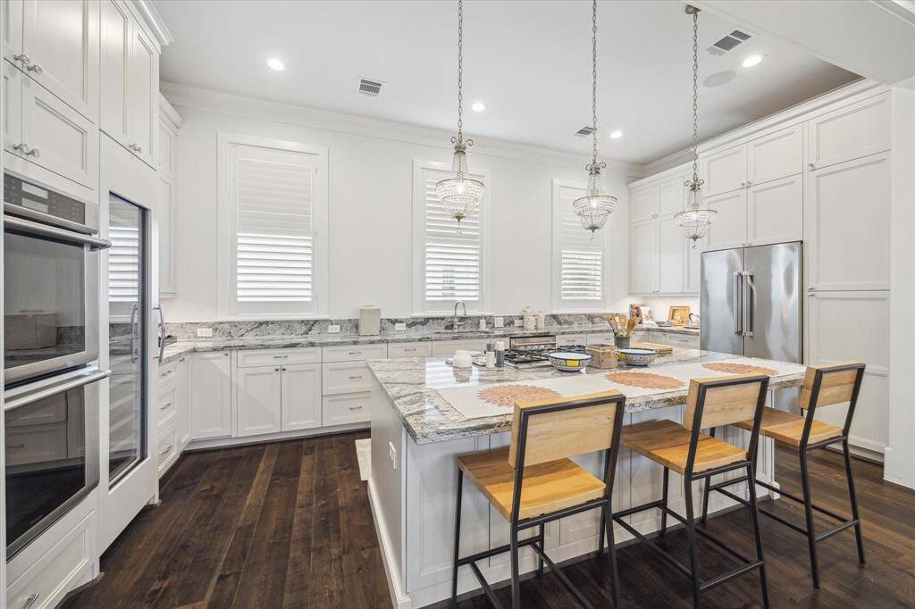 The Chef's kitchen is a true masterpiece,  featuring a large Cambria quartz island, matching countertops, premium Thermador appliances, custom cabinetry, and a 92-bottle wine fridge.