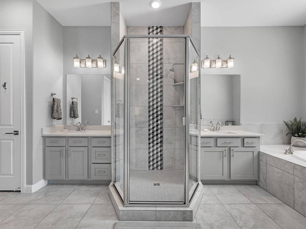 Primary Bathroom with separate vanities, walk in shower and soaking tub.