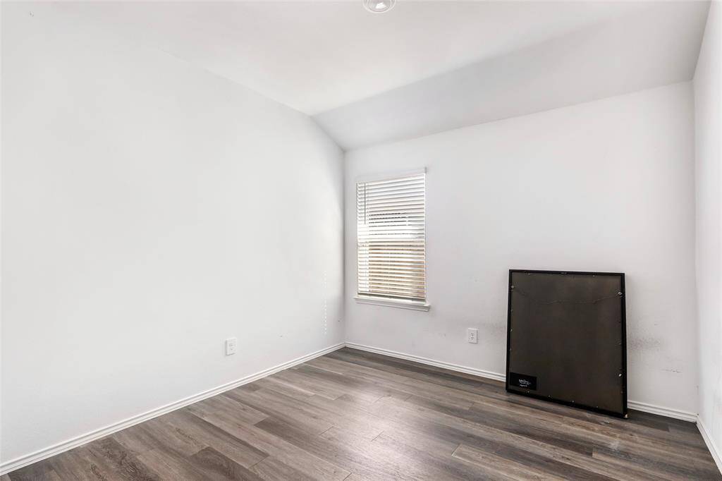 Bright, cozy room with a single window and hardwood floors, featuring neutral walls. Great space for a home office or small bedroom.
