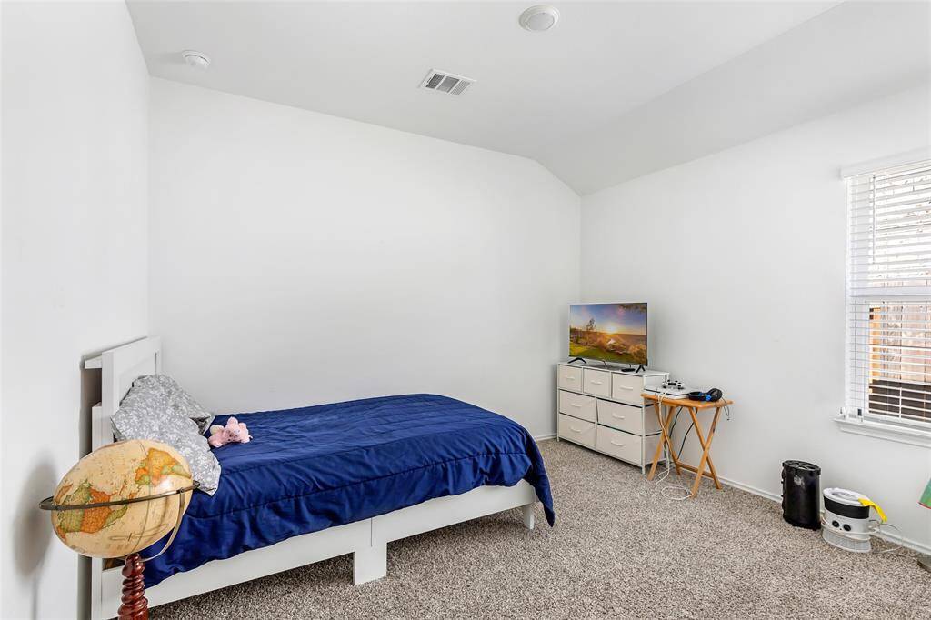 The room has neutral walls, carpeted flooring, and a simple, cozy layout.