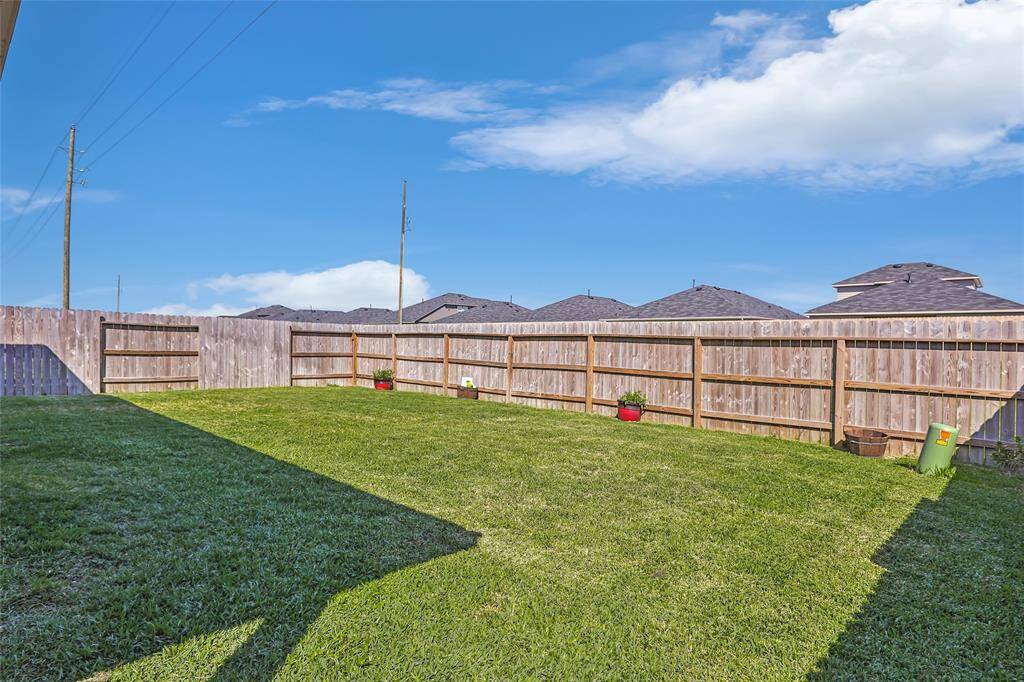 Spacious fenced backyard with well-maintained lawn, perfect for outdoor activities and gardening.