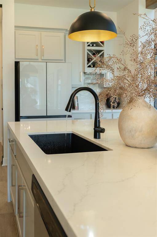 Sleek and modern appliances, as well as the pendant lights above the island are just a few of the upgrades you will find in this home. Designer detail - black sink - WOW!