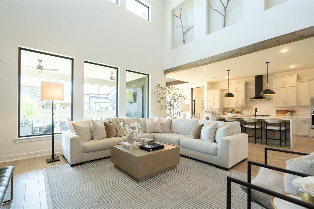 High ceilings, large windows and open concept living, make it a great place to relax with the family. Designer detail - wood beams and 'Artavia branches' sculpture. Note - select furnishings may be available for separate purchase