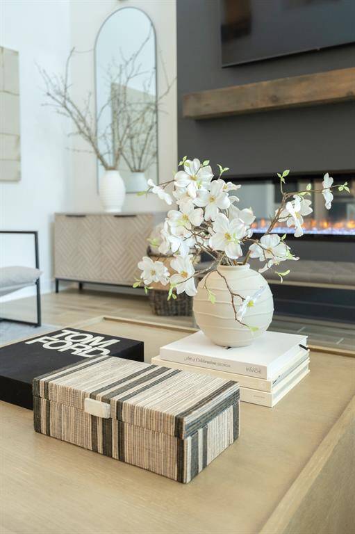 The modern, sleek fireplace serves as a sophisticated focal point, enhancing the living area's design and ambiance. Designer detail - custom mantle
