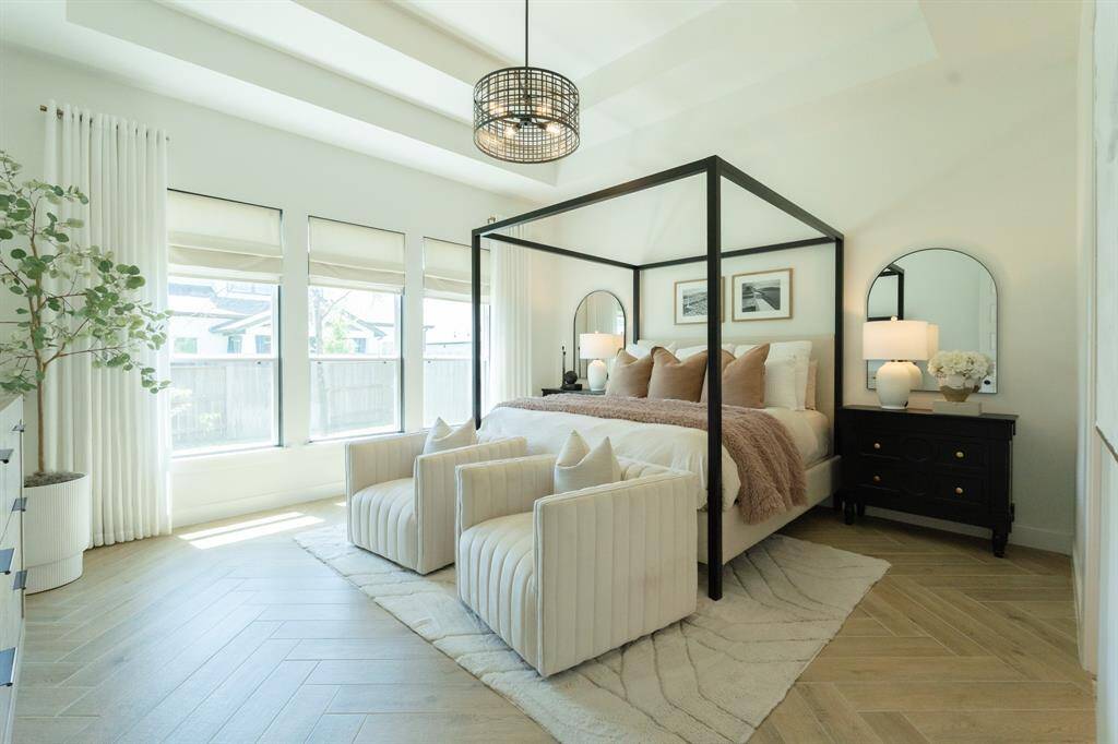Imagine retreating to your private suite, featuring tray ceilings, herringbone-patterned floors, and large windows that flood the space with natural light. Designer detail - herringbone floor design, custom light figure