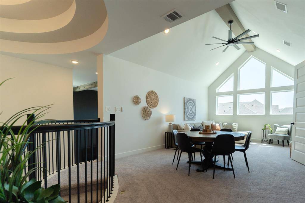 Games anyone? A wide beam adds architectural charm, perfectly complementing the expansive multi-paned windows that flood the gameroom with natural light. Together, these elements along with a sleek fan create a bright, airy atmosphere that feels both open and inviting.
