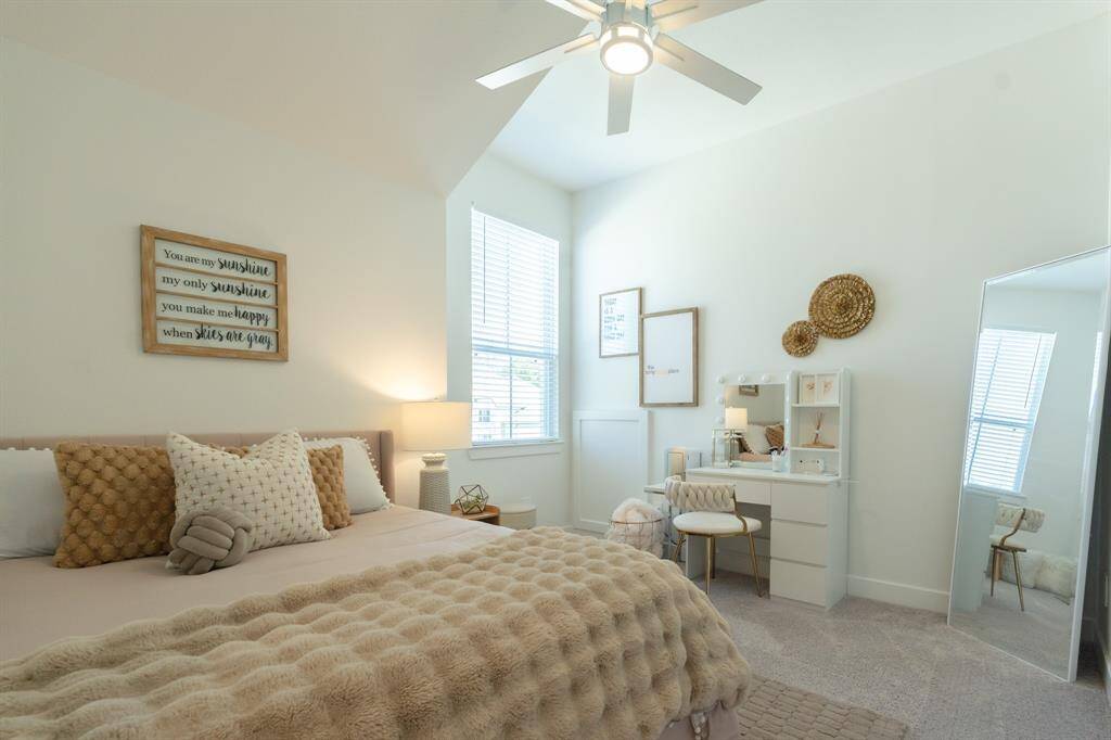 This bright upstairs bedroom features a neutral color palette that amplifies the natural light, creating a fresh and welcoming atmosphere with room for a seating or desk area