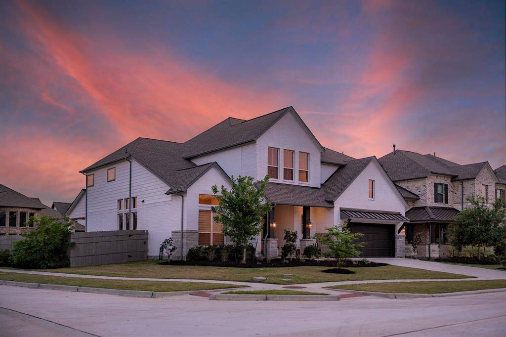 This modern home in Artavia sits on a desirable corner lot, where clean lines and a white brick exterior stand out against a lush, landscaped lawn. Thoughtfully designed with privacy in mind, the backyard offers a peaceful retreat—perfectly blending contemporary style with a prime location.