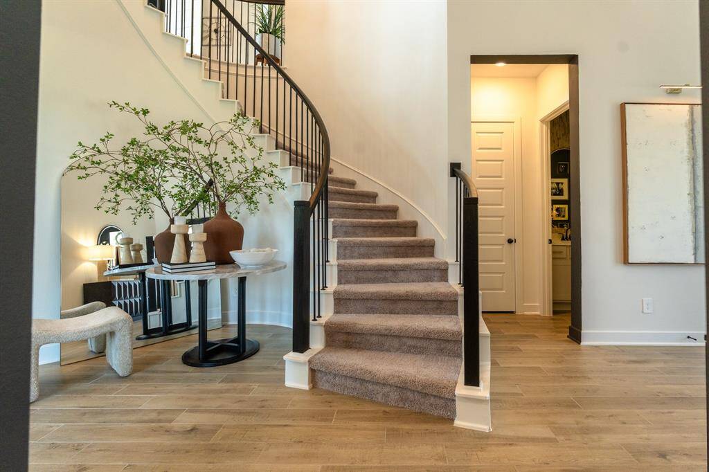 An elegantly curved staircase pairs beautifully with soft, neutral tones to create a timeless and inviting entry. The clean lines of the dark newel posts and balusters really define the staircase
