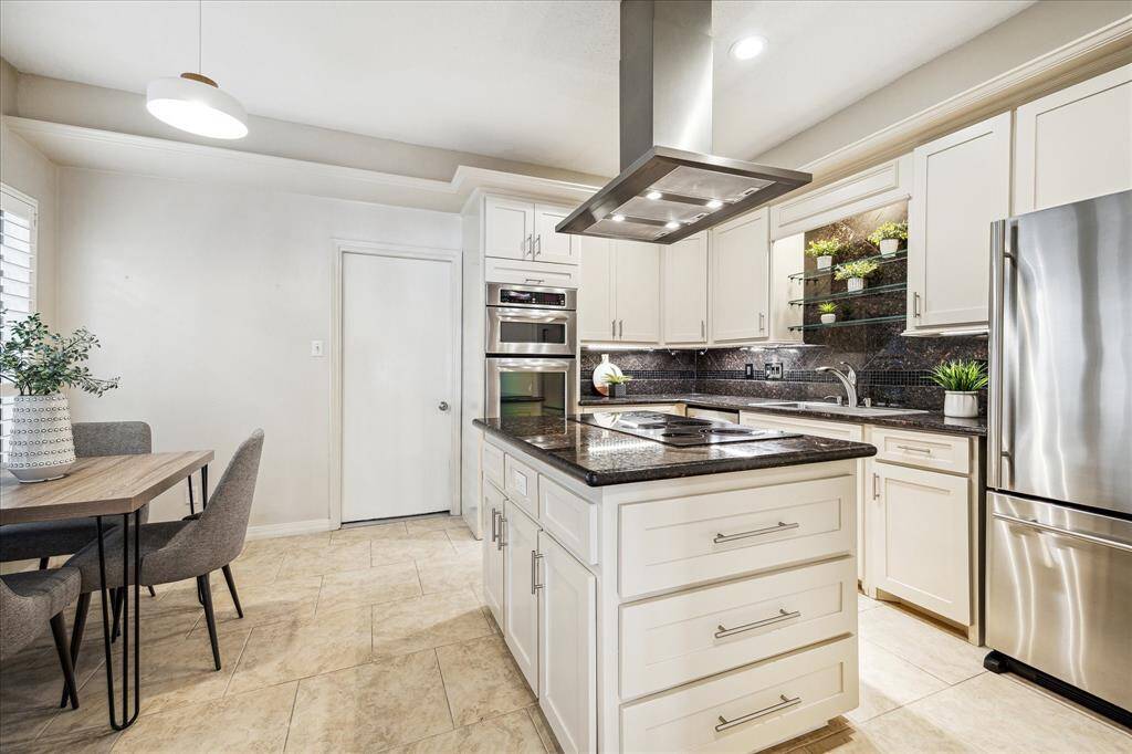 KITCHEN.  Updated in 2017 with neutral, white cabinetry and stylish granite countertops.   Electric cooktop WITH a vent hood (not a downdraft).   Stainless steel appliances.