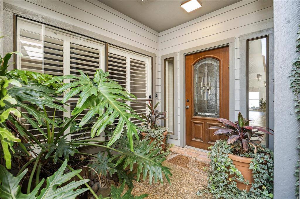 FRONT ENTRY. A covered, private entry surrounded by lush greenery. Perfect to keep deliveries hidden from the street