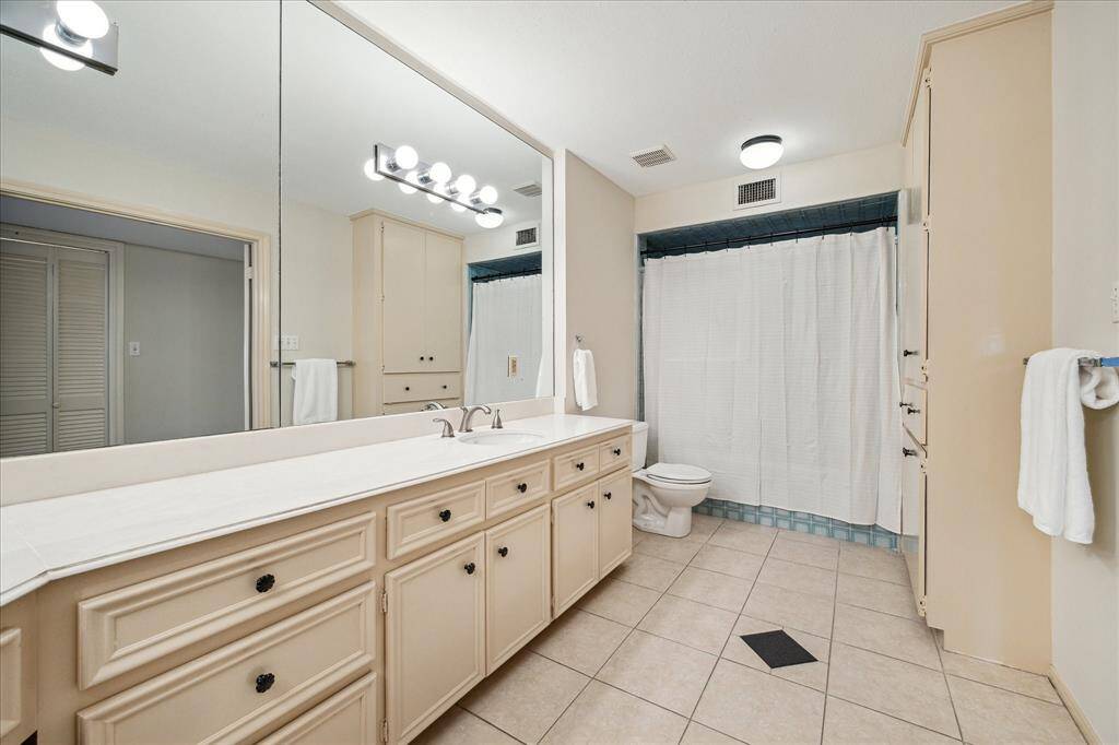 PRIMARY BATHROOM.   With double sinks and tub/shower, the primary bathroom is an ideal footprint for an easy update down the line.