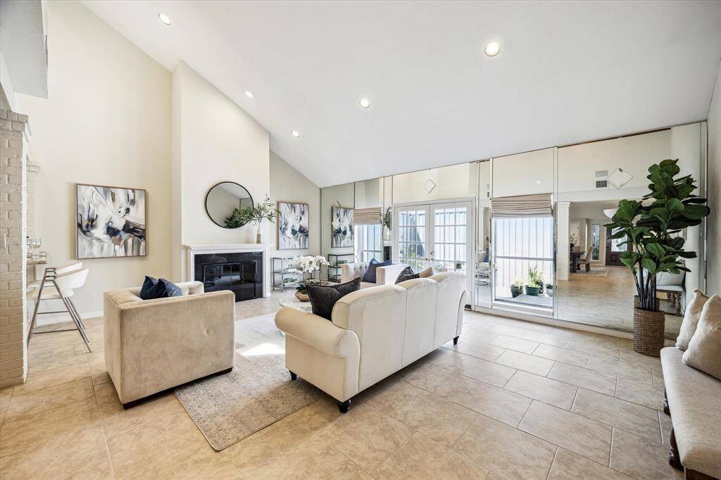 LIVING. Located at the back of the home. Note the spectacular vaulted ceiling and neutral color palette. Patio doors open up onto a private courtyard.