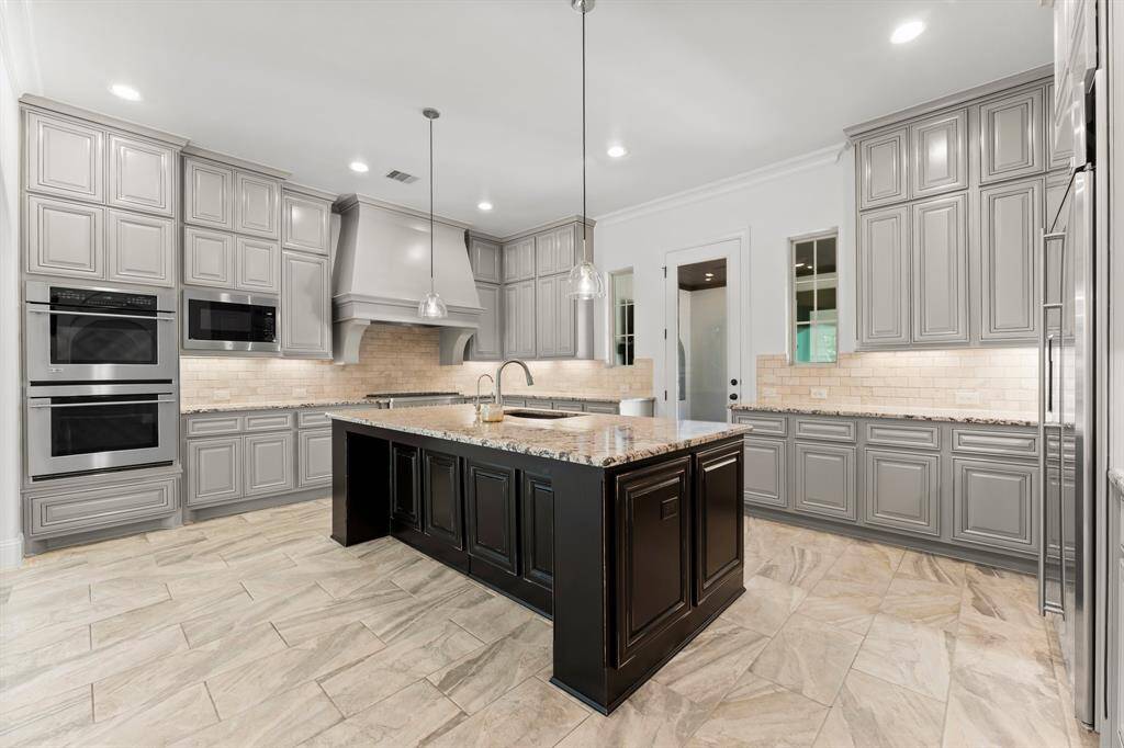 Extended height cabinetry and double ovens yield ample function in this stylish kitchen.