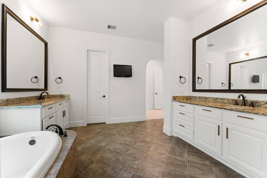 Generously sized Primary Bath also features his and hers closets.