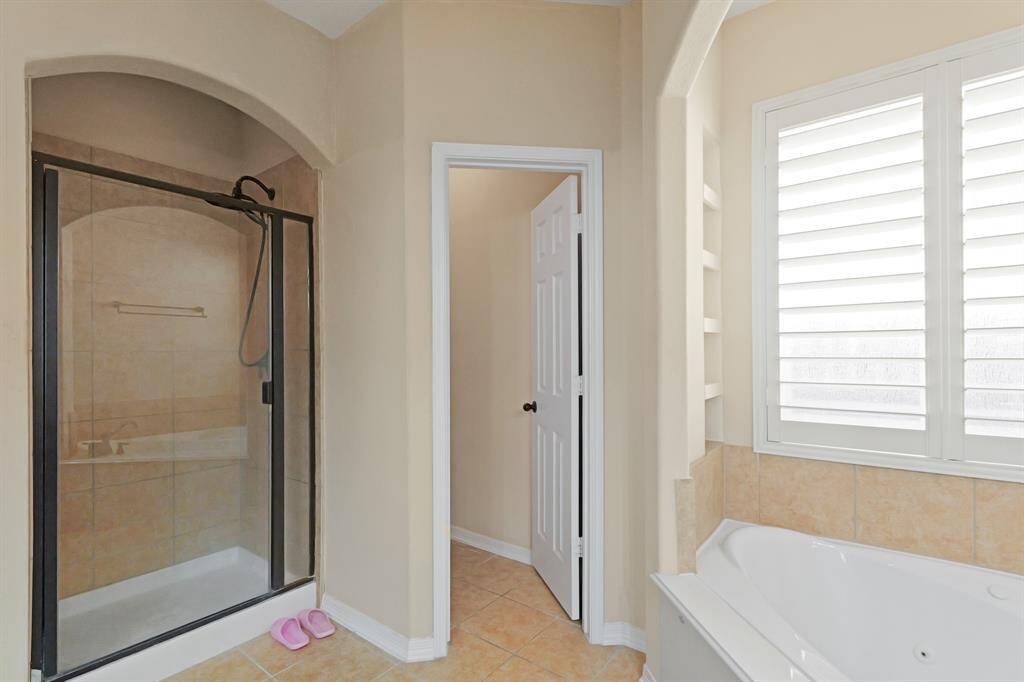 This bathroom features a glass enclosed shower with gorgeous tile walls.