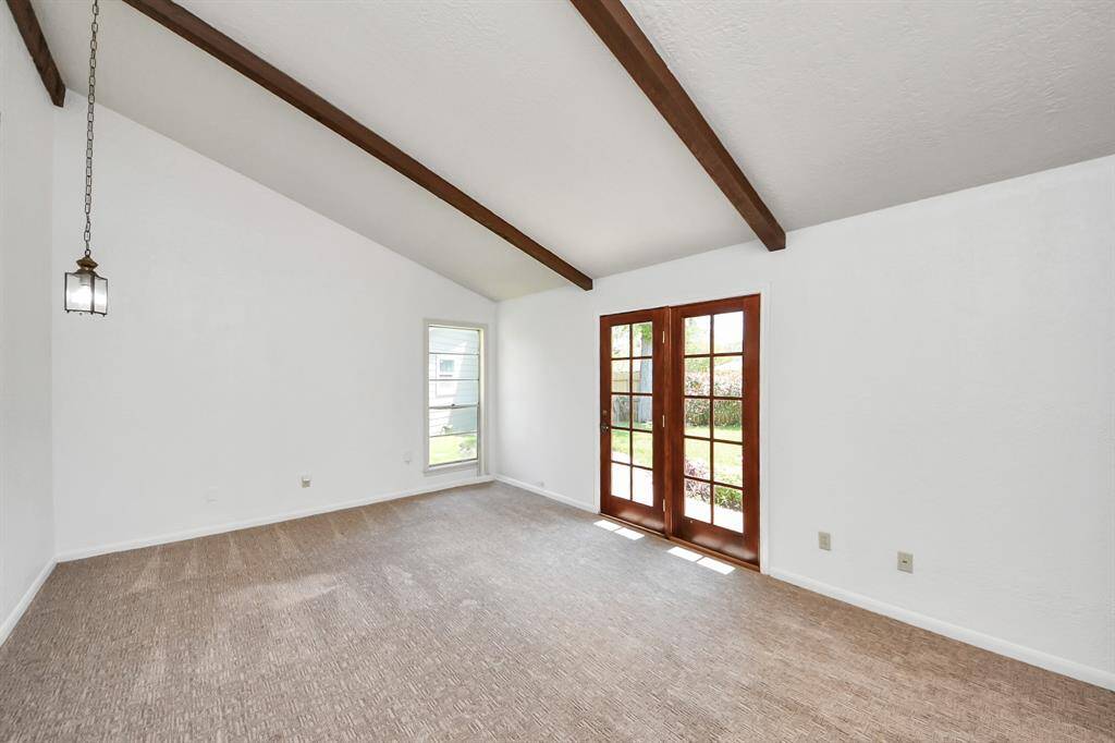Fresh paint provides a clean, neutral palette, while French doors offer both access to and lovely views of the beautiful backyard.