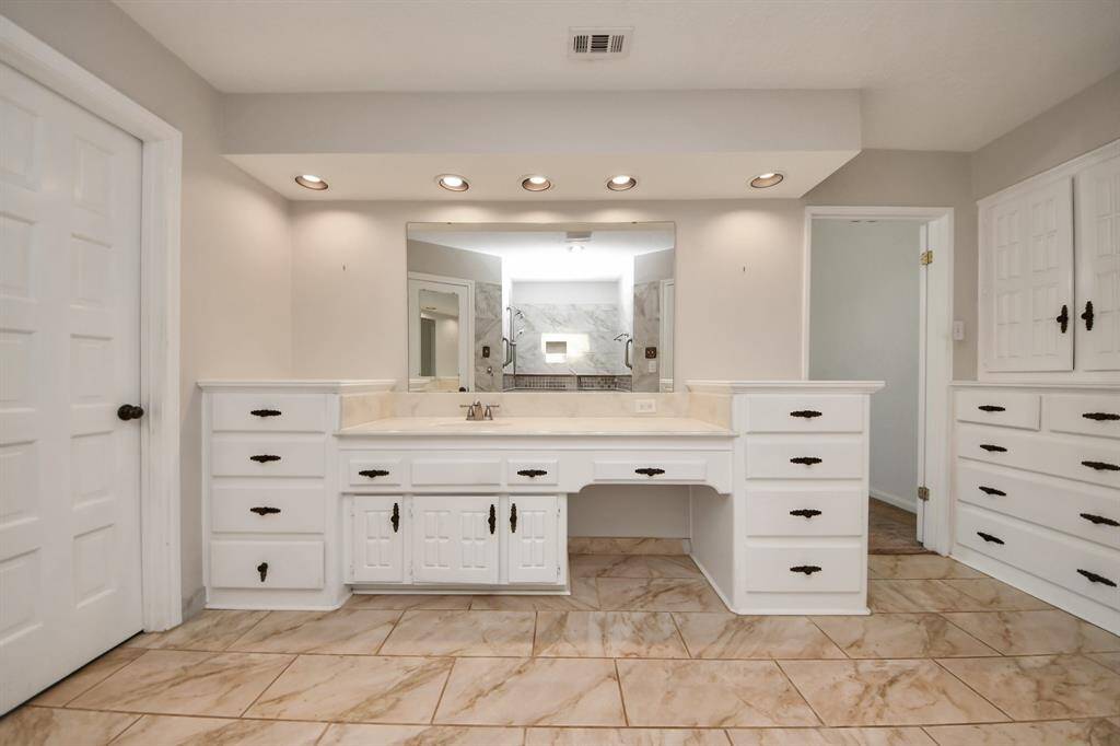 In addition to the spacious layout, the bathroom features a dedicated vanity area for makeup application, offering both convenience and adds to the overall functionality,