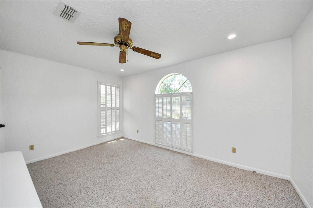 One of the two secondary bedrooms in this split floor plan features nice windows with shutters.