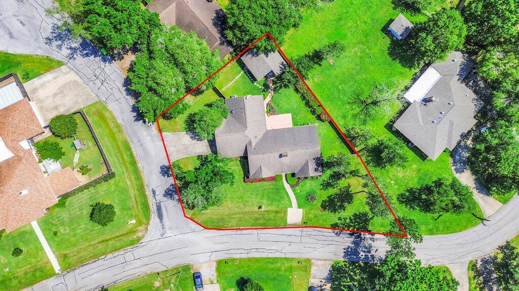 An aerial view showcases the home situated on an expansive corner lot of over 13,000 square feet, highlighting the generous outdoor space and well-designed layout of the property.