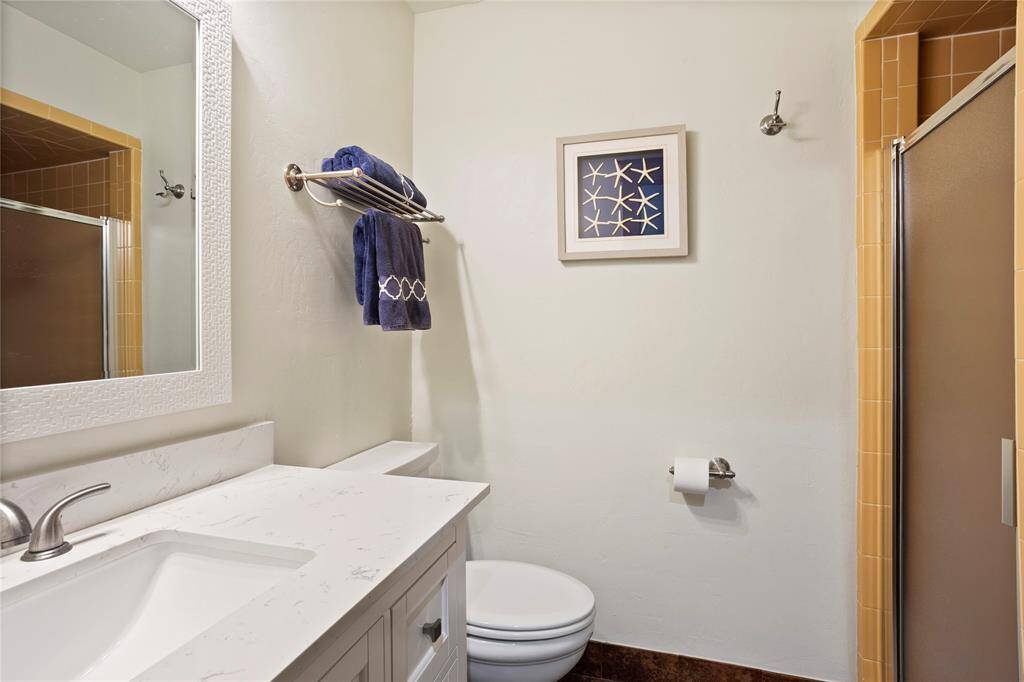 Guest bath with 2023 updated vanity and sink.  Walk-in shower has been meticulously maintained for vintage charm.