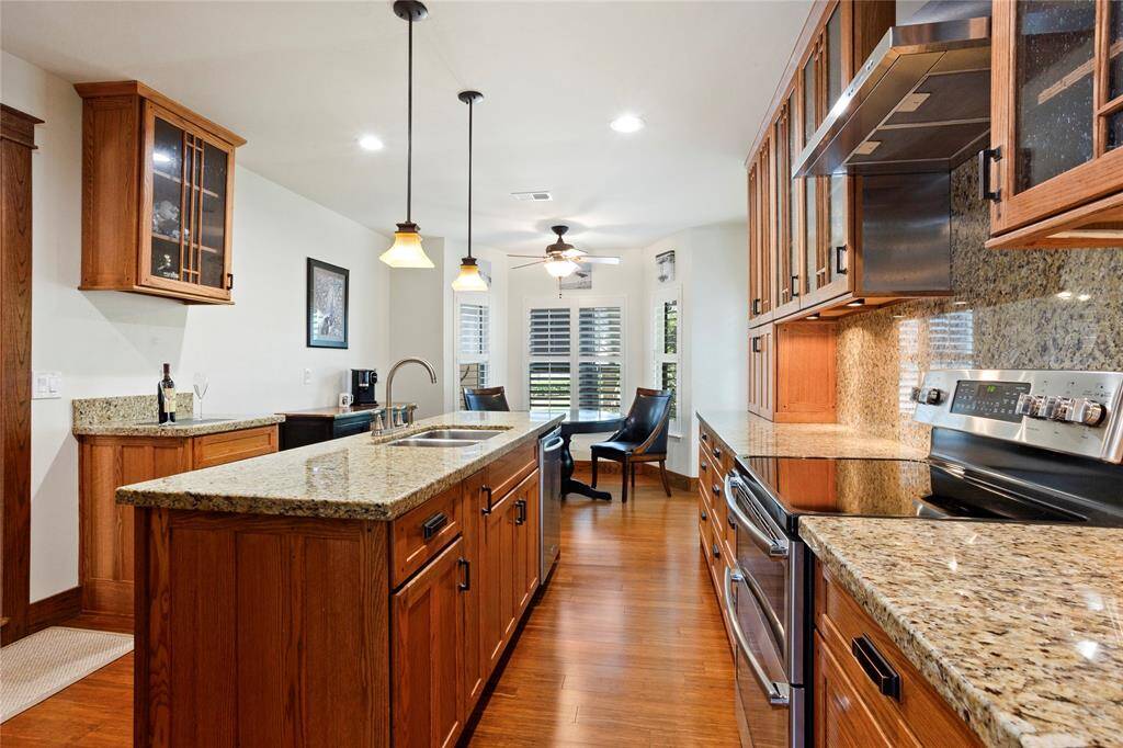 This kitchen features custom cabinets with beautiful glass-front uppers, and a mix of lower cabinets and drawers.  The range has double ovens for stress-free meal time.
