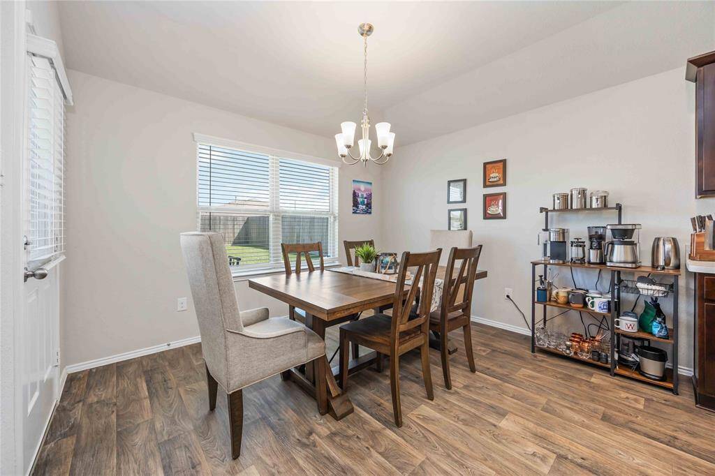 The dining room features an elegant chandelier and large French-style windows that offer a lovely peek into the backyard—ideal for enjoying meals with a view.