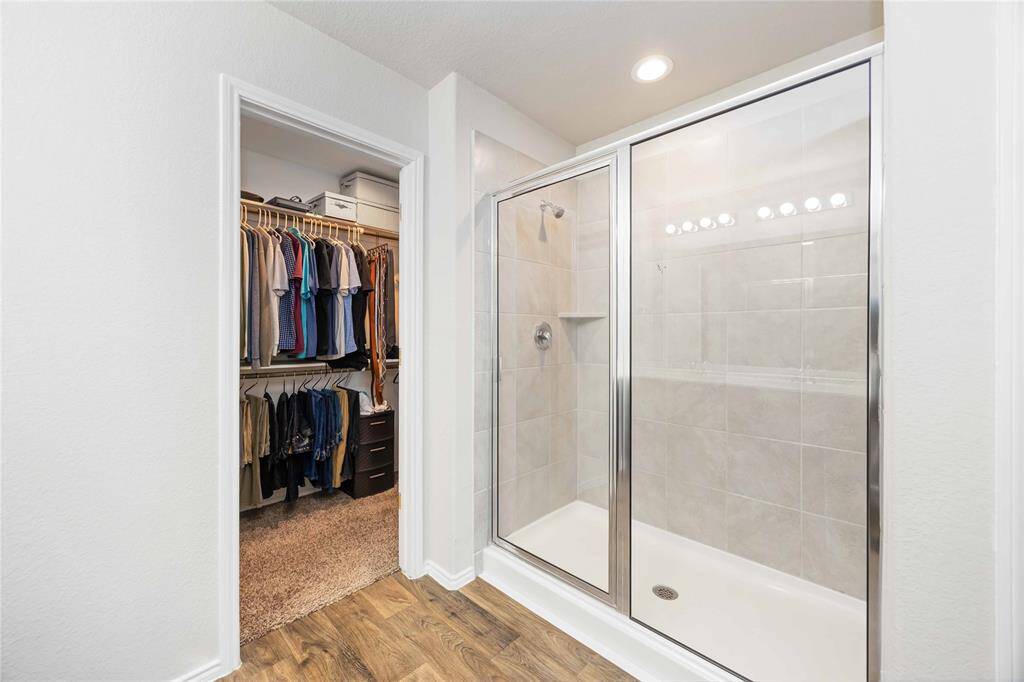 Refresh and relax in the sleek, glass-enclosed shower of the primary bathroom, offering a modern touch and spa-like experience.