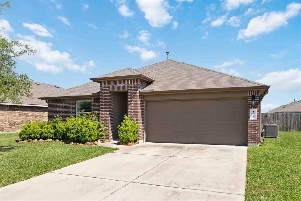 The wide driveway leads to a two-car attached garage—offering ample parking, extra storage space, and direct access to the home.