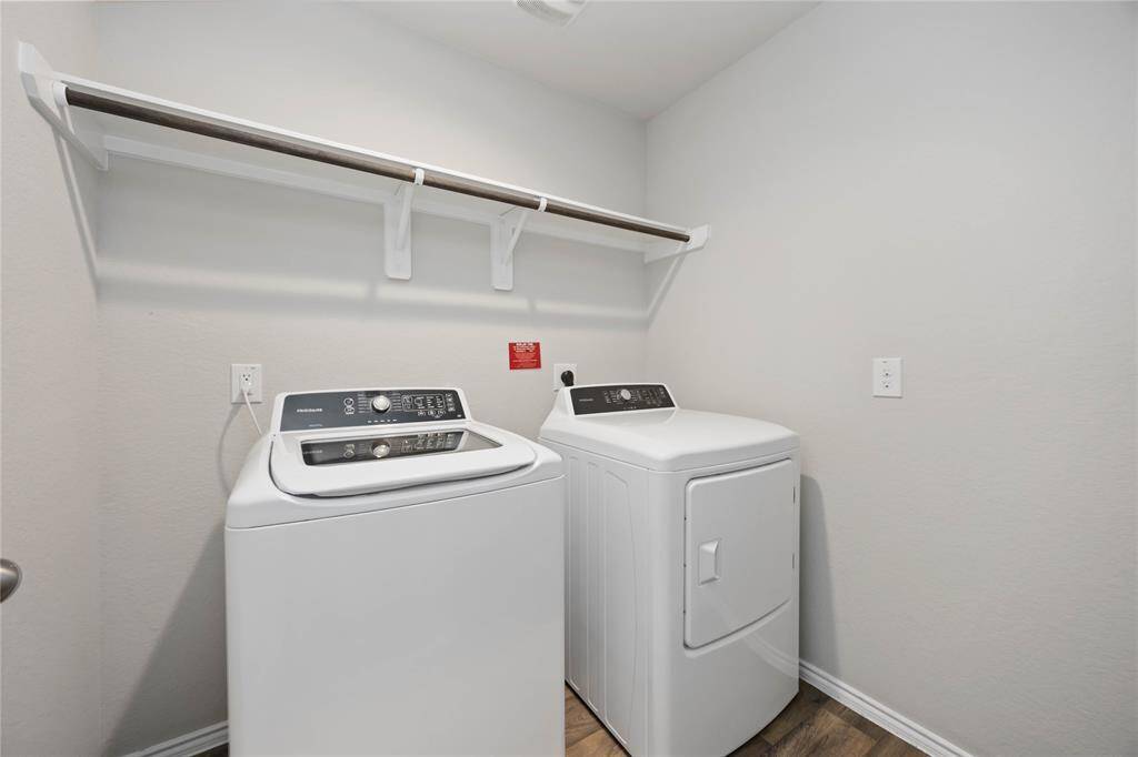 This convenient laundry space features open built-in shelving above, offering easy access to laundry essentials.