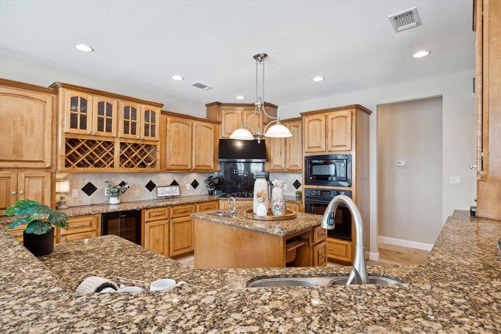 This kitchen has a wine rack with glass-doors on the cabinets above.