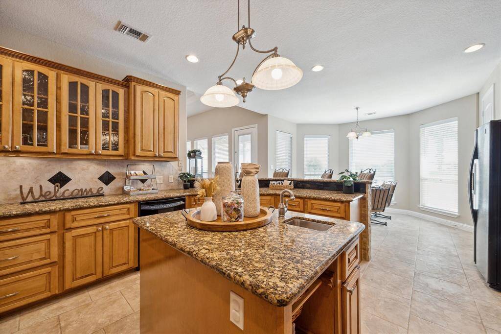 Notice the custom island with pull-out baskets, drawers, cabinets and a prep sink.