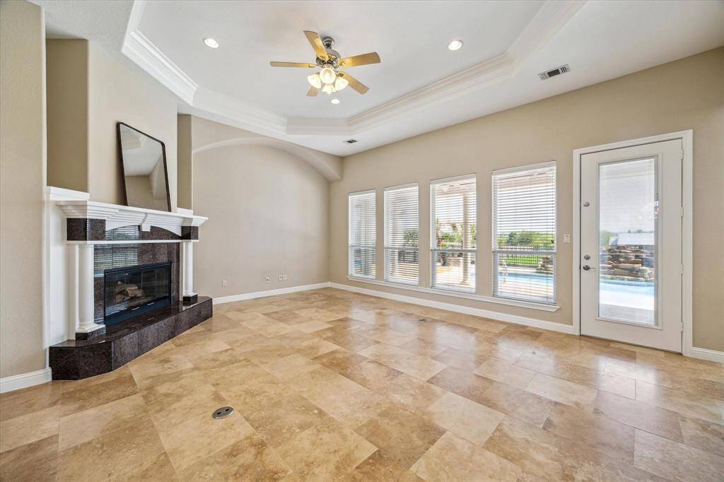 The extra large family room and this beautiful fireplace perfectly placed so that you can see the full backyard and pool just outside through the four extra large windows.