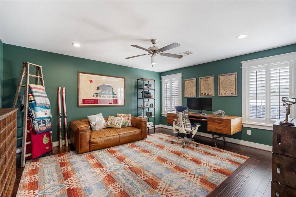 This third bedroom is currently being used as a home office.  The deep green walls add warmth and sophistication, creating an inviting atmosphere for productivity or relaxation.